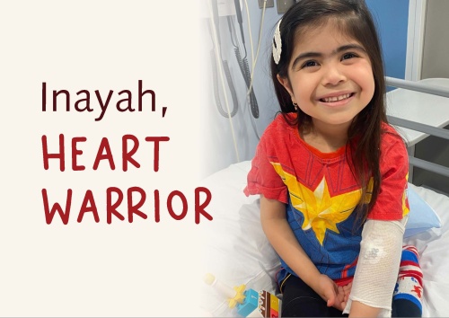 Inayah heart warrior sitting on hospital bed and smiling at camera